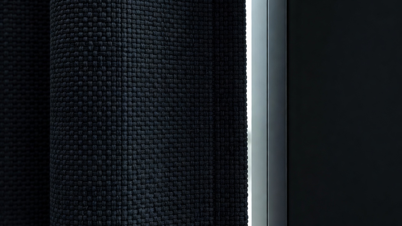 Close-up of dense blackout curtain weave overlapping the edge of a window