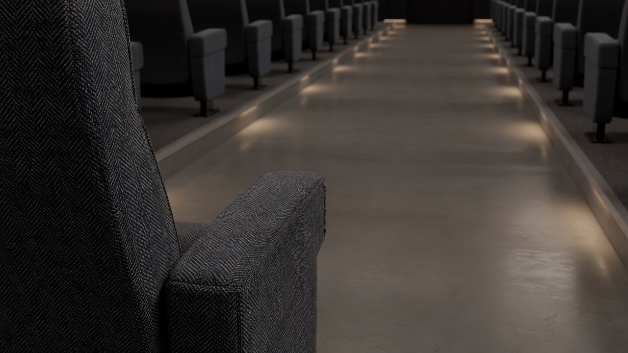 Close-up of a woven seat armrest beside an uncluttered cinema walkway